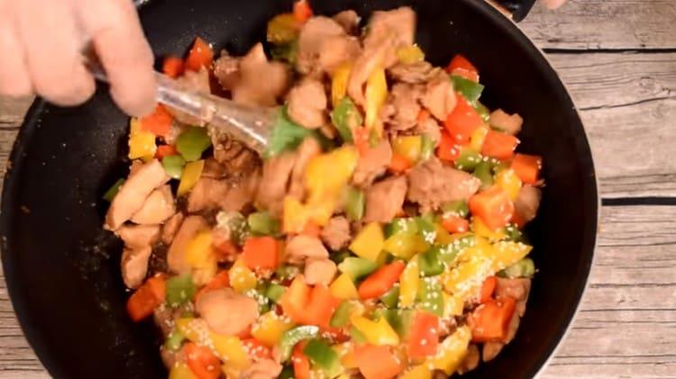 Amestecați puiul cu piper și semințe de susan, tocați până când ardeiul este moale.