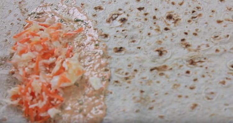 Отгоре на соса разпределяме зеле с моркови.