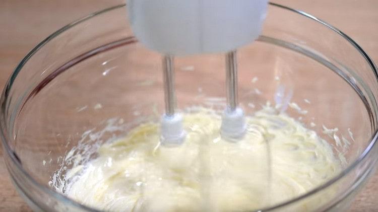 Separat die Butter mit einem Mixer weiß schlagen.