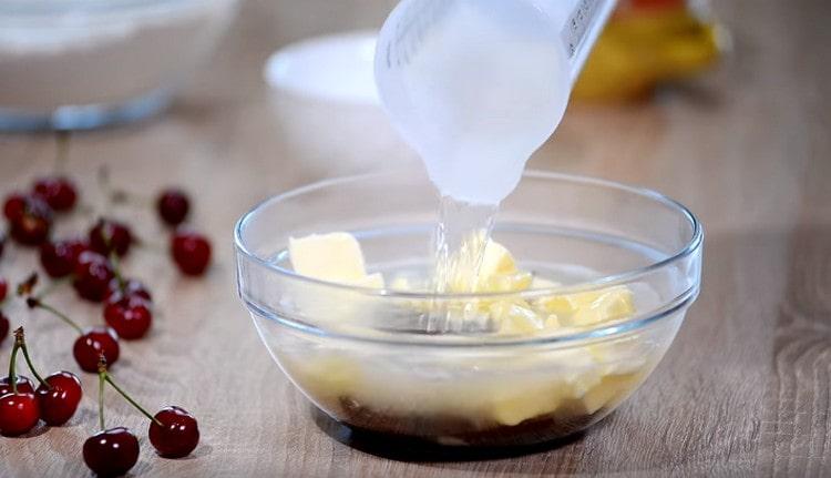 Fügen Sie die Butter der zerbrochenen Schokolade in Stücke und füllen Sie alles mit kochendem Wasser.