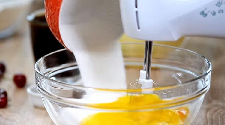 Zucker zu den Eiern geben und schaumig rühren.