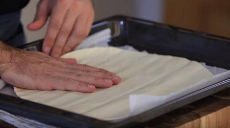 Læg et ark færdig butterdej ud på en bageplade.