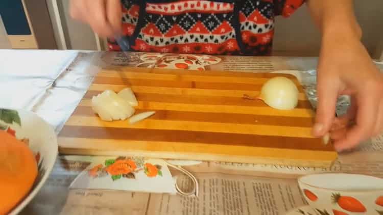 Pour cuisiner un lapin à l'étouffée avec des légumes, hachez l'oignon