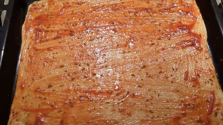 Para hacer los ingredientes de la pizza, ponga la salsa sobre la masa.