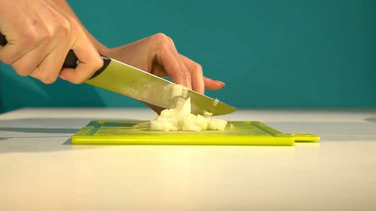 Para cocinar el fletán en el horno, pique la cebolla.