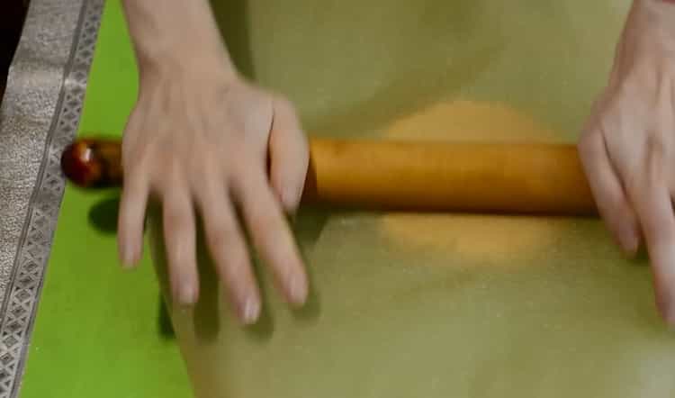 Rulează aluatul pentru a face prăjiturele într-o tigaie