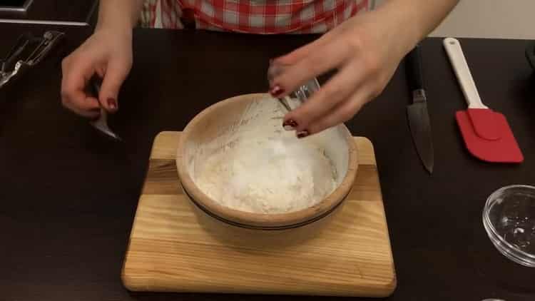 Setacciare la farina per fare i biscotti con gocce di cioccolato