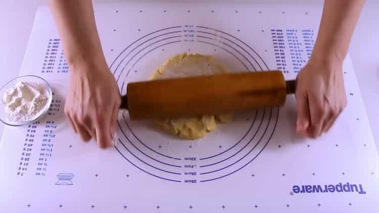Estire la masa para hacer galletas con manzanas.