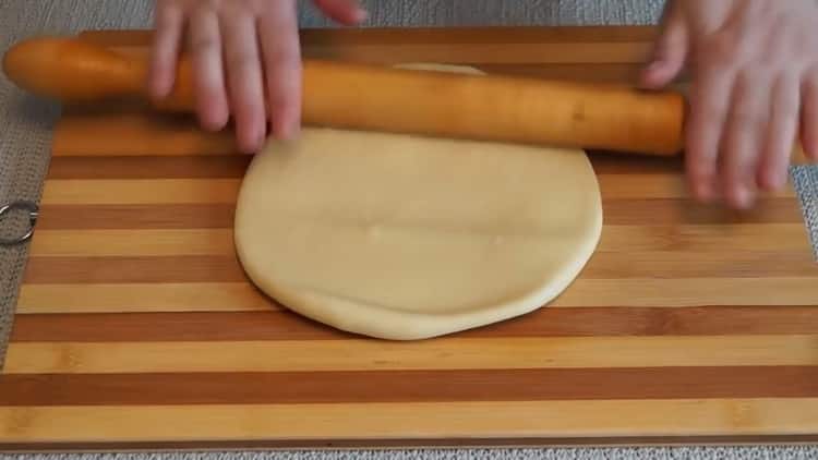 Estirar la masa para hacer una tarta de champiñones en el horno