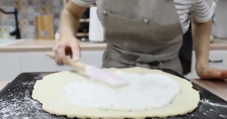 لعمل 4 بيتزا جبنة ، قم بتغطية العجينة بالصلصة