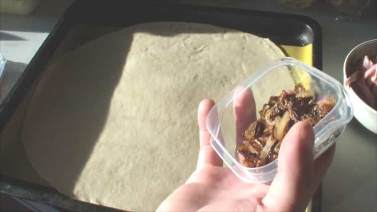 Rulează aluatul pentru a face pizza asortată