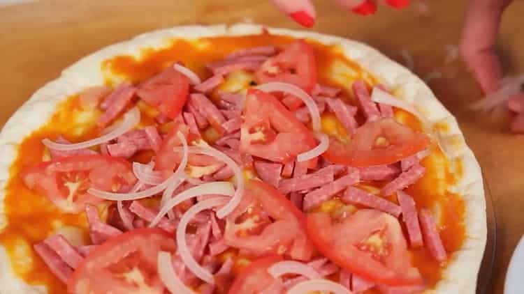 Lägg alla ingredienser på kakan för att laga pizza i mikrovågsugnen