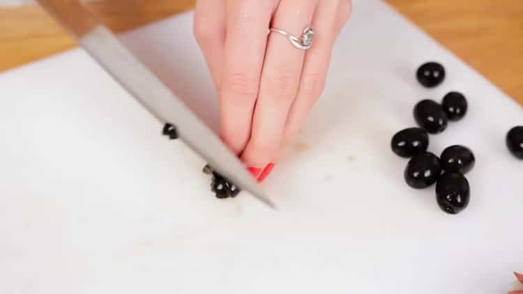 Skär oliver för att laga pizza i mikrovågsugnen