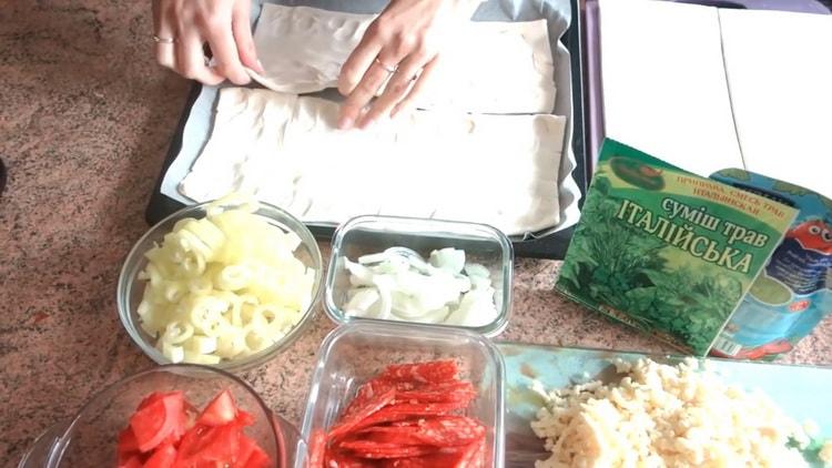 За да приготвите пица от бутер тесто във фурната, поставете тестото върху лист за печене