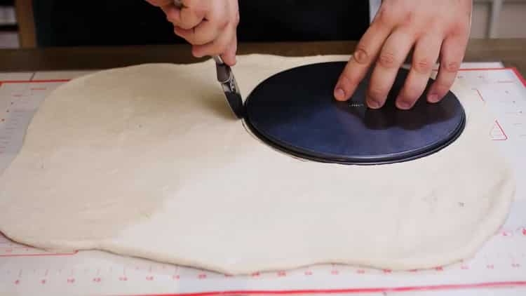 Pentru a face o plăcintă cu pizza, rulează aluatul