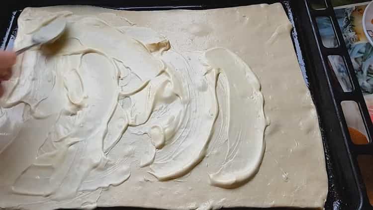 Yengeç çubukları ile pizza yapmak için hamuru fırın tepsisine yerleştirin