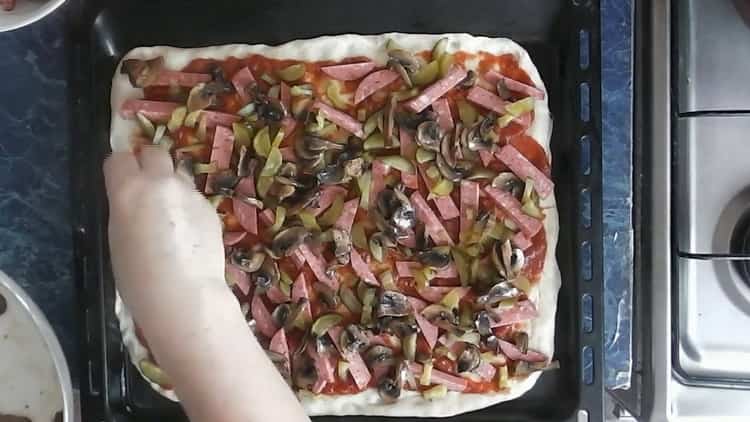 Upang makagawa ng pizza na may adobo, ilagay ang mga kabute sa kuwarta