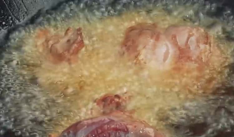 Cuire le pilaf sur un feu dans un chaudron, faire frire la viande