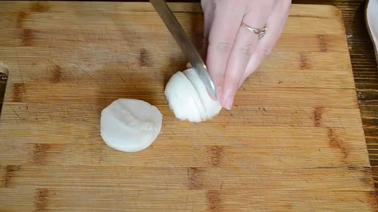Para cozinhar o peixe com creme de leite no forno, pique a cebola