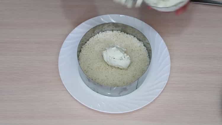 Pentru a pregăti o salată cu avocado și somon, ungeți orezul cu brânză de căsuță