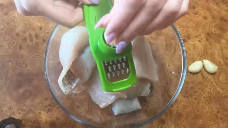 Enligt receptet för att laga gädda abborre i ugnen, gnugga vitlök