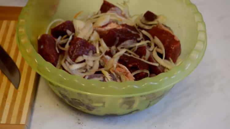 For at tilberede oksekødspyd, hugg løg