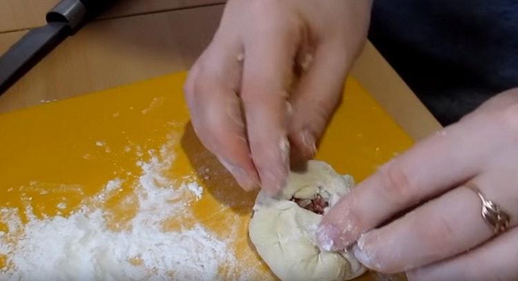 Wir verteilen die Füllung in der Mitte des Kuchens und sammeln den Teig darum, so dass ein kleines Loch übrig bleibt.