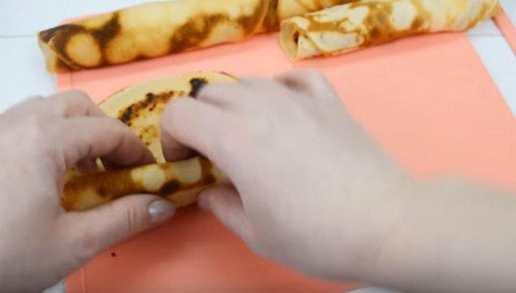 Răsuciți clătita într-un sul.