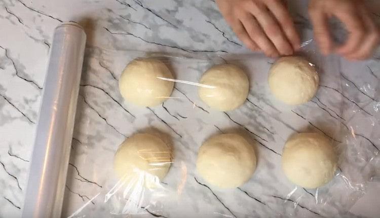Rotiți aluatul în bile și acoperiți-le cu folie.