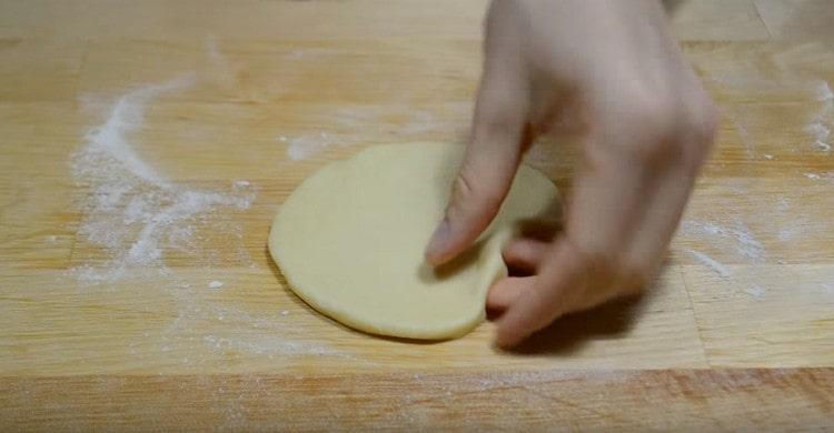 Enrollamos cada bola en un pastel redondo.