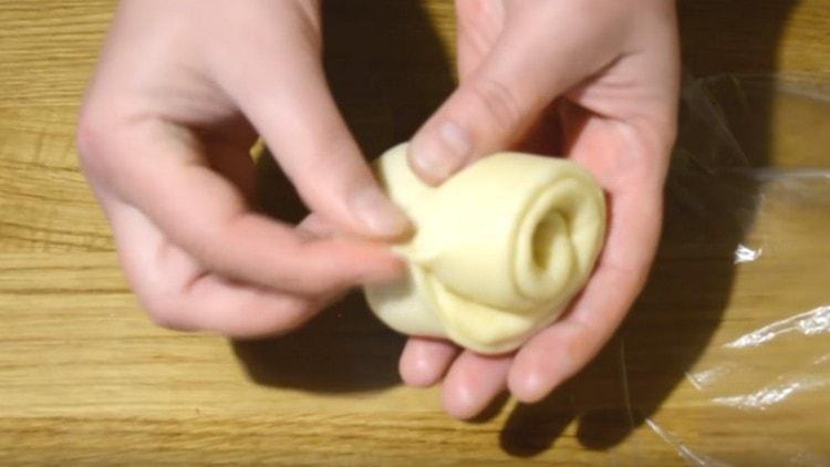 Después de arrancar los bordes, tuerza un pastel largo en un rollo y obtenga una rosa.