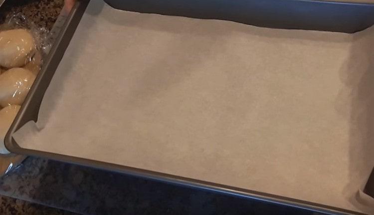 Acoperim foaia de copt pe care vom coace chiflele cu pergament.