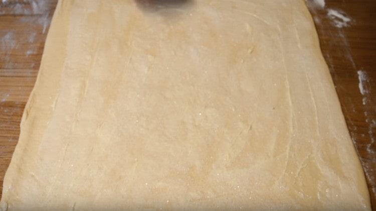 يرش العجين بالسكر.