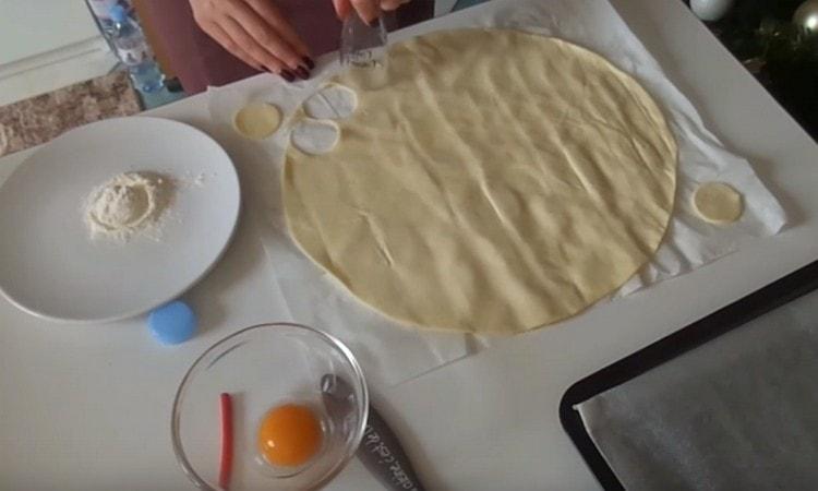 Pomocí kráječe cookie nebo skla jsme vyřízli kruhy z vrstvy těsta.