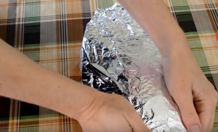 Enrole cuidadosamente a carpa em papel alumínio para que o suco não vaze durante o cozimento.