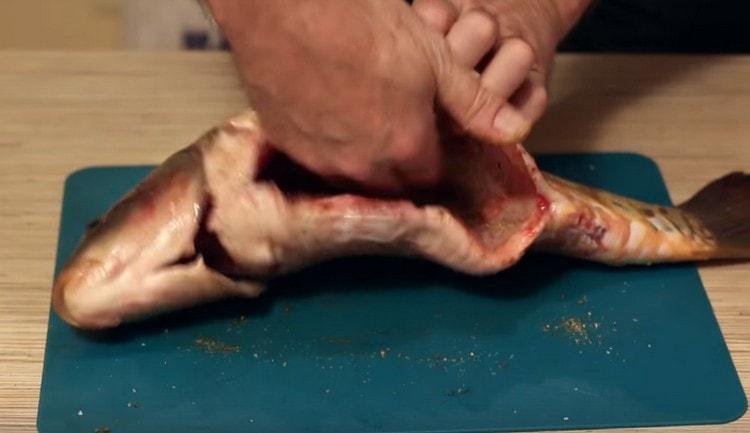 Frecați peștele cu un amestec de sare și condimente.