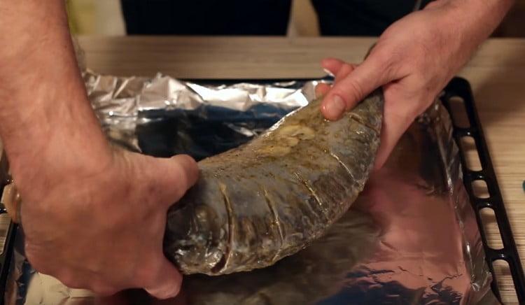 Cu partea unsă, așezați crapul pe o foaie de copt acoperită cu folie.