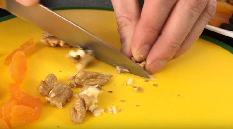 Torkade aprikoser, skär muttrar i bitar.