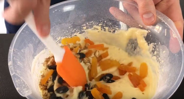 Lägg torkad frukt och nötter till degen. rör om.