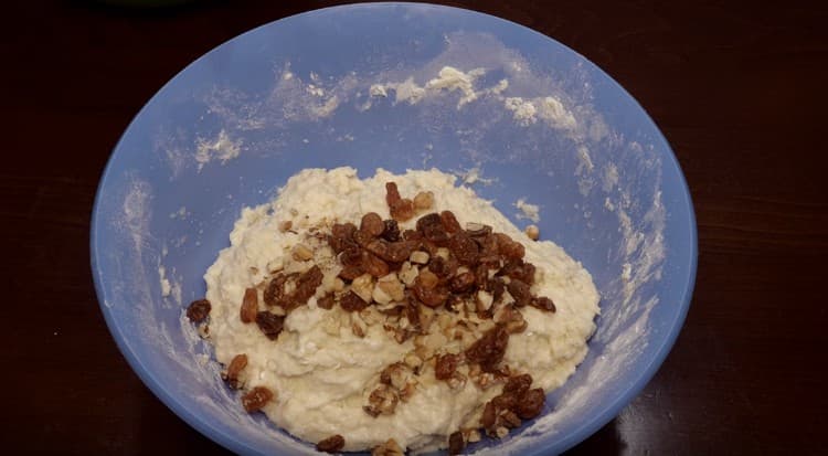 Avem un aluat gros lipicios, amestecăm nucile cu stafidele.