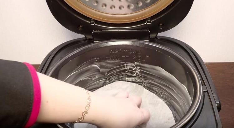 Aliniem partea inferioară a vasului multicooker uns cu o foaie de pergament.