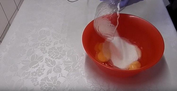 Adăugați zahăr în ouă.