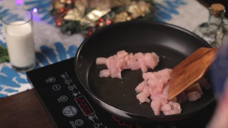Frite os pedaços de frango em uma panela.