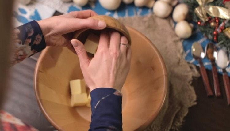 Espalhe a manteiga cortada em fatias em uma tigela.