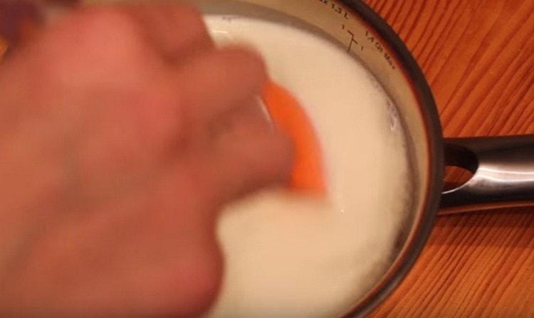 Punem tocană cu lapte și zahăr pe aragaz și aducem la fiert.