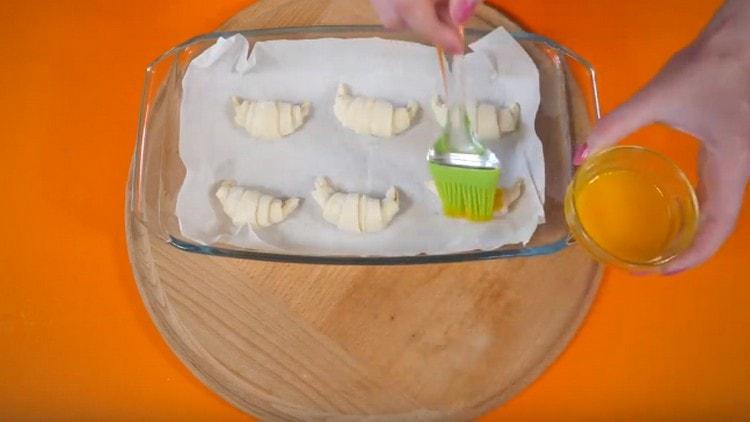 Amb el rovell batut, greixeu els croissants.