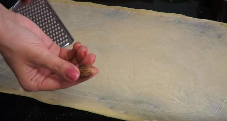 Riv muskotnöten på degen.