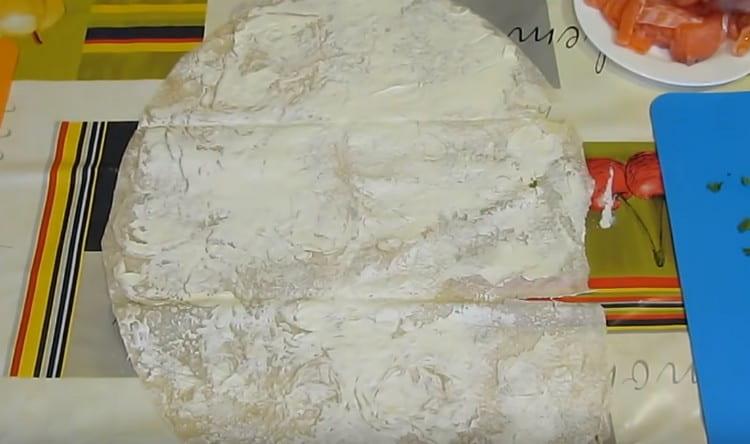 Colocamos o pão pita em cima da mesa e unte com creme de queijo.