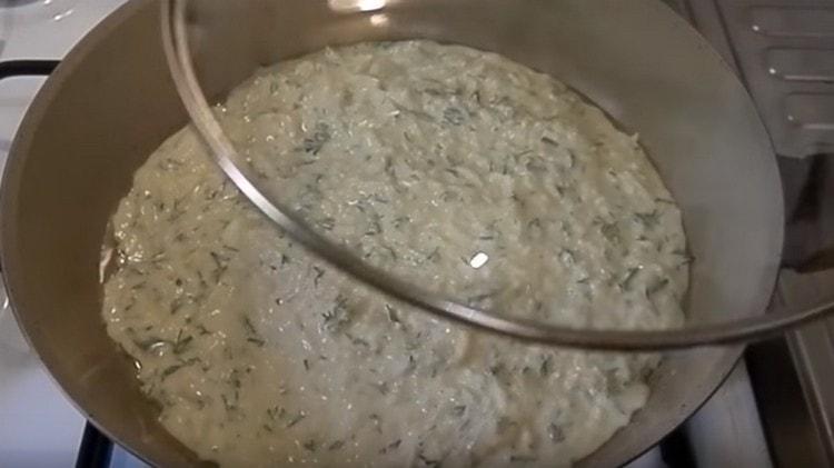 Vyrovnejte těsto na pánvi a přikryjte víkem.