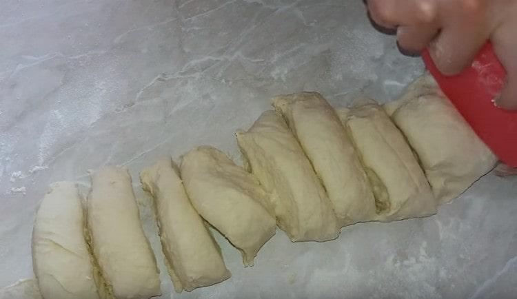 Facem un rulou din aluat și îl împărțim în 12 părți.